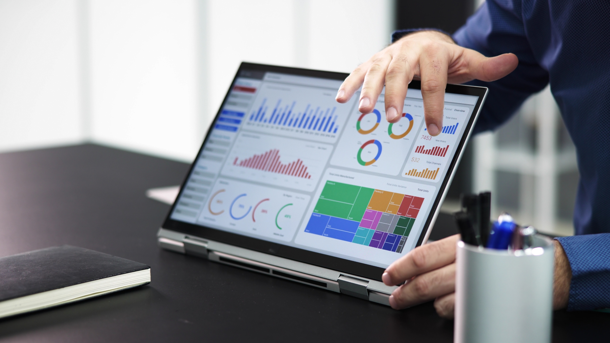 A marketing strategist from Upvited collaborating with a creator, analyzing positive growth charts on a laptop